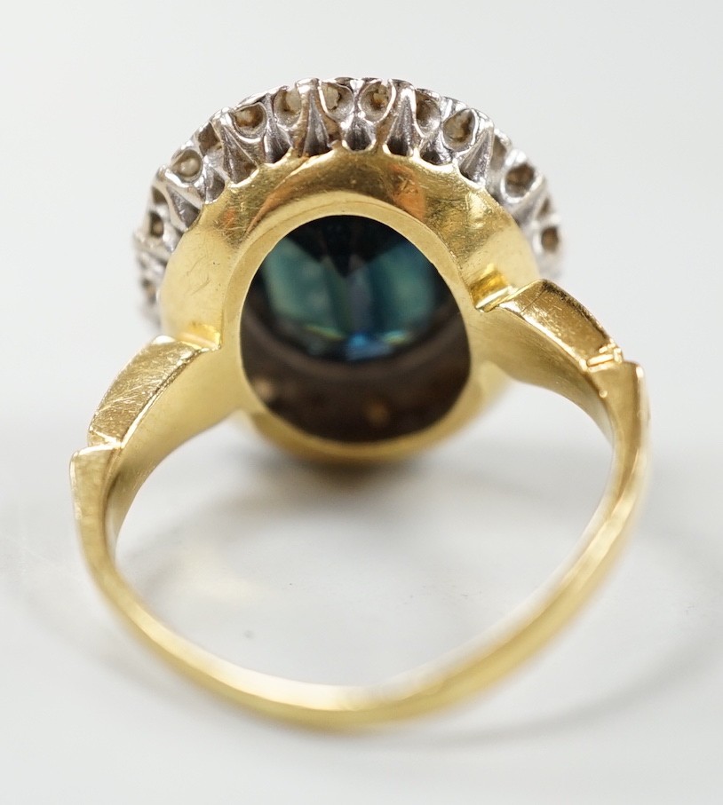 A 1970's? 18ct gold, single stone oval cut sapphire and illusion set diamond cluster ring, size O/P, gross weight 8.2 grams.